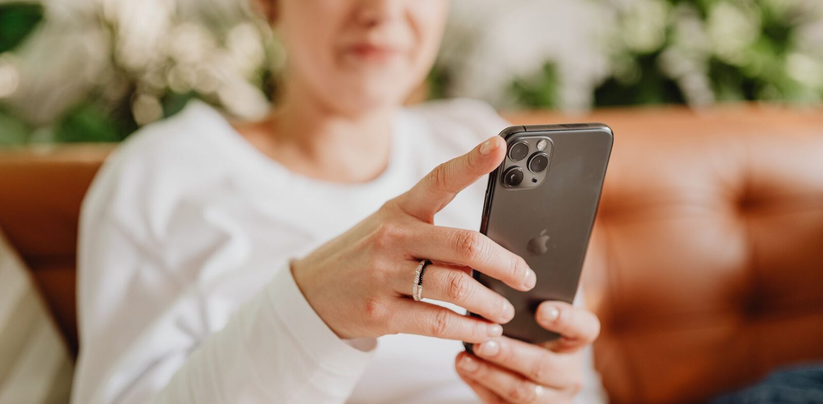 Žena na gauči prochází v mobilu nabídky