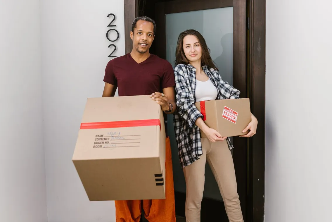 Neue Mieter mit Umzugskartons in der Wohnungstür