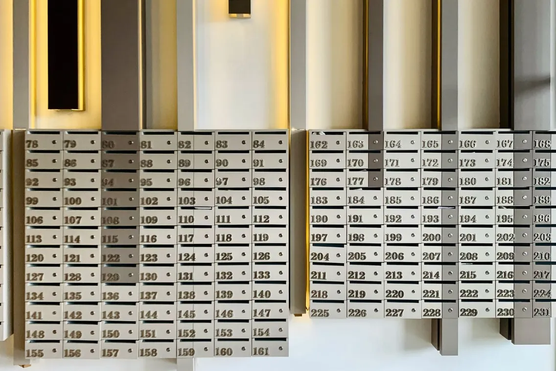 Eine Wand mit nummerierten Briefkästen im Eingangsbereich eines Wohnhauses